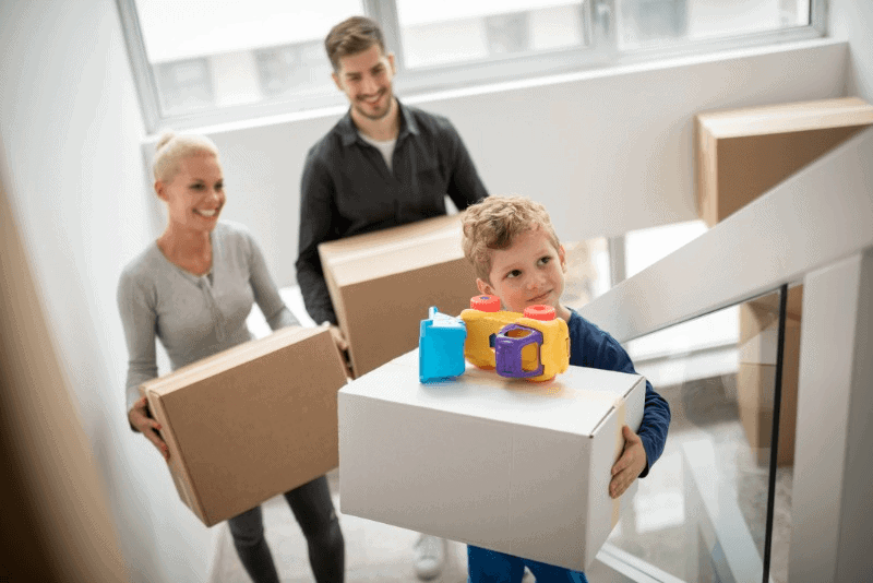 Family carrying boxes up stairs