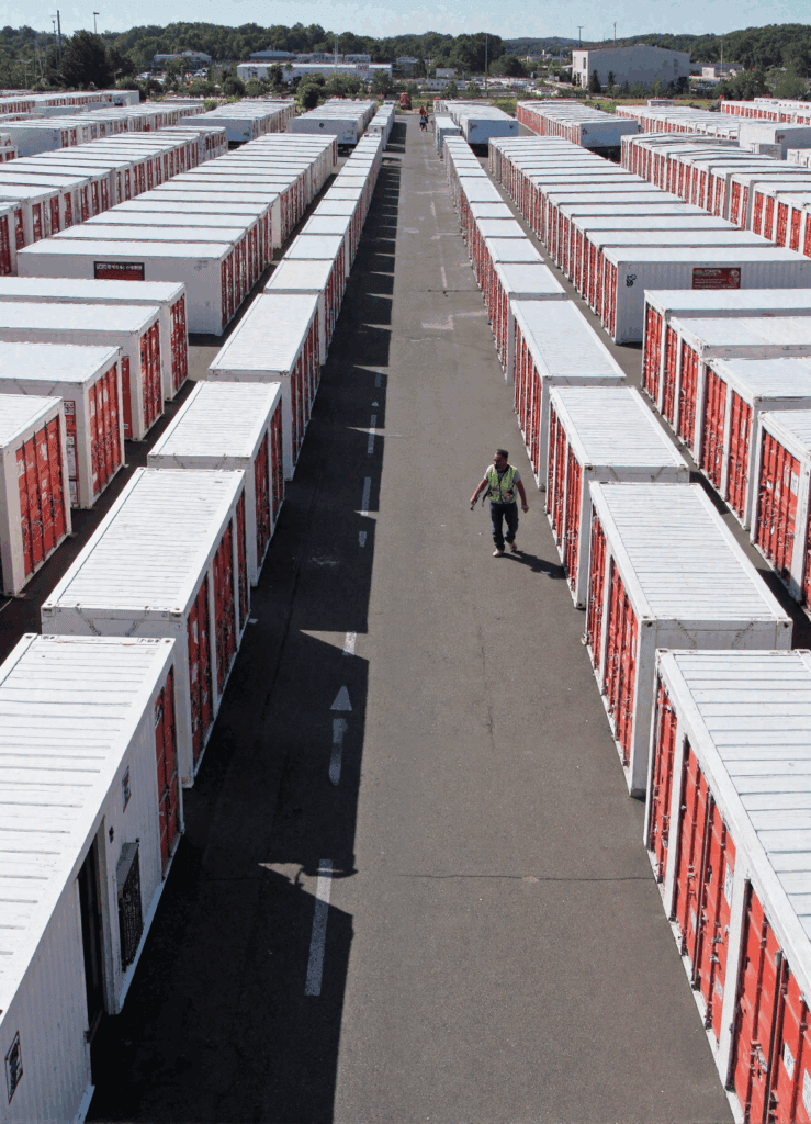 Rows of white storage containers on paved surface.