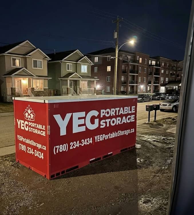 Red portable storage container on residential street at night