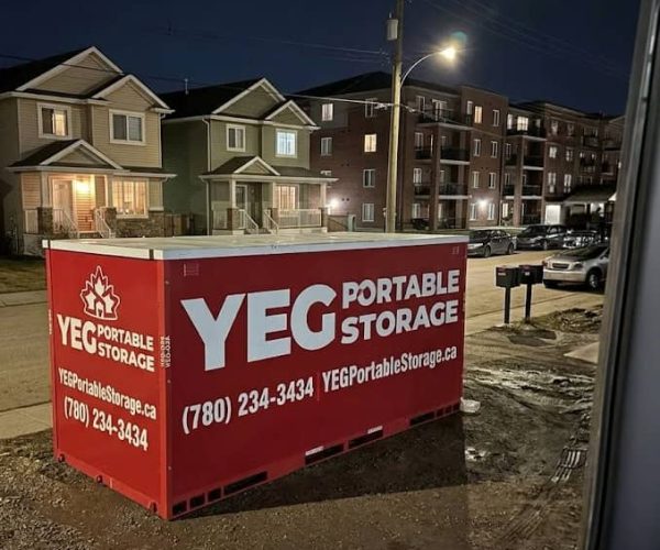Red portable storage container on residential street at night