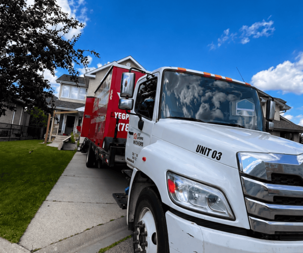 YEG Movers truck parked outside a suburban home