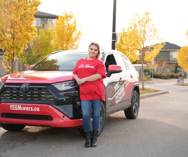 YEG Movers employee beside branded moving vehicle.